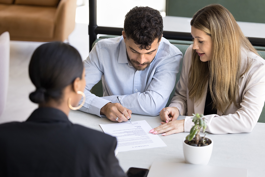 Couple Signing Contract with the Realtor